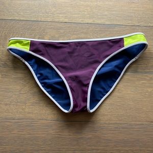 Reversible Lululemon swim bottom in purple with neon yellow and navy blue.